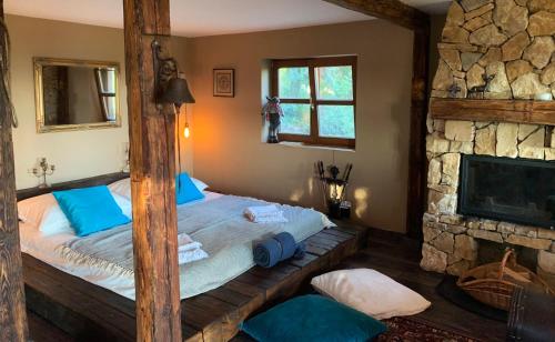 Schlafzimmer mit einem Bett und einem Steinkamin in der Unterkunft Hilltop Hideout in Szentendre