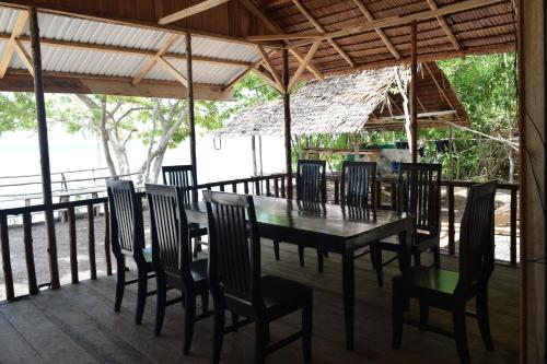 jadalnia ze stołem i krzesłami na tarasie w obiekcie Tanjung Kalemo Resort w mieście Batudaka