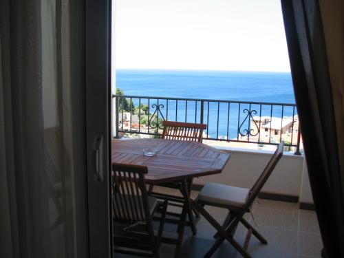 a table and chairs on a balcony with the ocean at Apartments Leut in Sveti Stefan