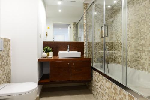 La salle de bains est pourvue d'un lavabo et d'une douche. dans l'établissement New loft with swimming pool at Parque das Nações!, à Lisbonne