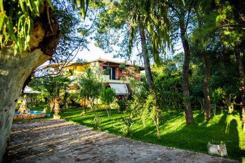 a house with a yard with trees and a driveway at Villa Swan in Lefkada