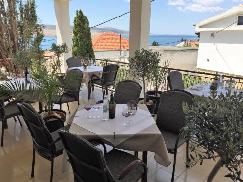 a restaurant with tables and chairs with a view of the ocean at Rooms & Pansion Odmor in Rovanjska