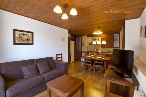 Apartaments La Peguera II في بارويرا: غرفة معيشة مع أريكة وغرفة طعام