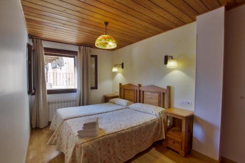um quarto com uma cama e um tecto de madeira em Apartaments La Peguera II em Barruera