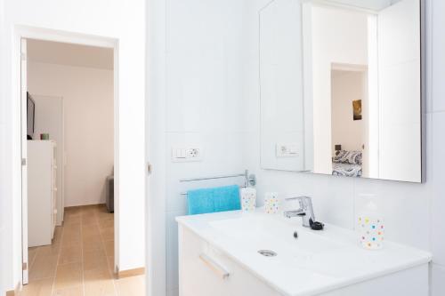 a white bathroom with a sink and a mirror at The wave house El Médano in El Médano