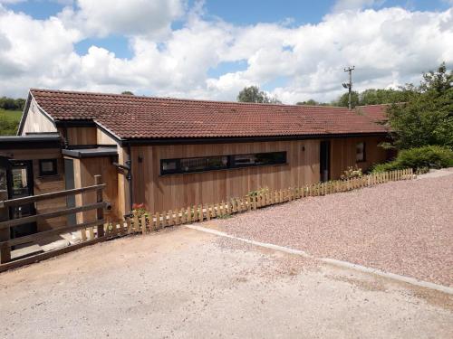 a building with a fence next to a driveway at Welsh Marches at Upper Glyn Farm in Chepstow