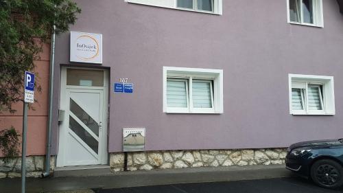 a purple building with a door and two windows at InOsijek- FEELS LIKE HOME in Osijek
