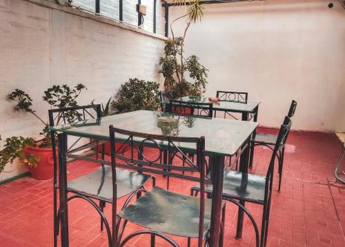 una mesa y sillas en una habitación con macetas en Hostel Lagares en Mendoza