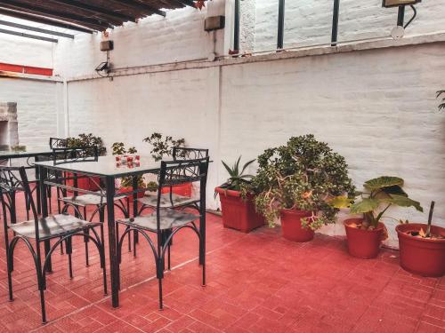 a patio with a table and chairs and potted plants at Hostel Lagares in Mendoza
