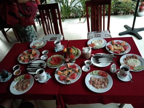 a red table with plates of food on it at Herbal Tea Homestay in Hoi An