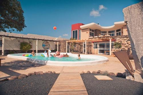een groep mensen in een zwembad in een resort bij Studio - Agua - Surf & Yoga Villa in La Pared