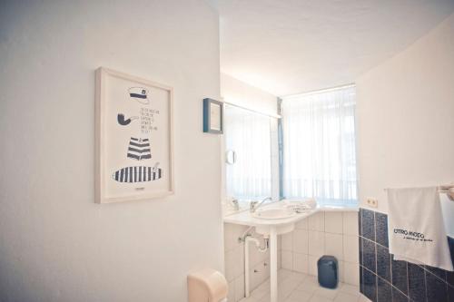 een witte badkamer met een wastafel en een spiegel bij Studio - Agua - Surf & Yoga Villa in La Pared