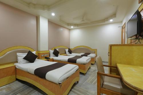 a hotel room with two beds and a television at Hotel Good Night in Ahmedabad