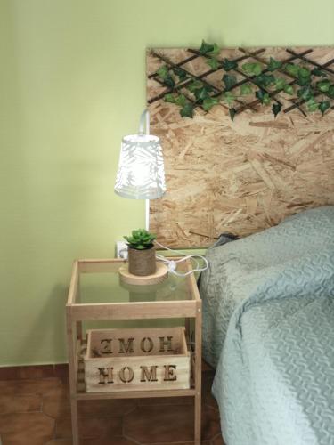 a lamp on a table next to a bed at Nature Guesthouse in Lagos