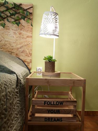 a table with a lamp on top of a bed at Nature Guesthouse in Lagos