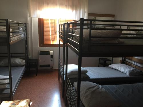 a room with three bunk beds and a window at Ostello Trentapassi in Zone