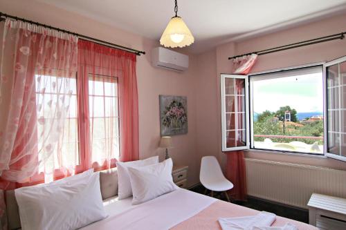 een slaapkamer met een bed en een groot raam bij VILLA RELAX in Skala Kallirakhis