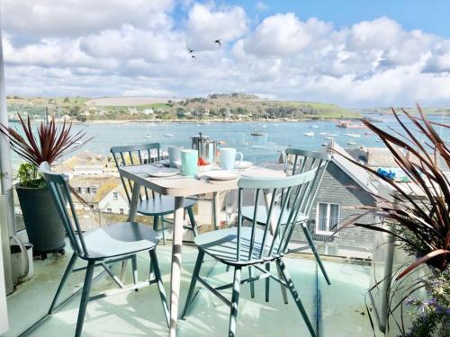a table and chairs on a balcony with a view of the water at Falmouth View in Falmouth