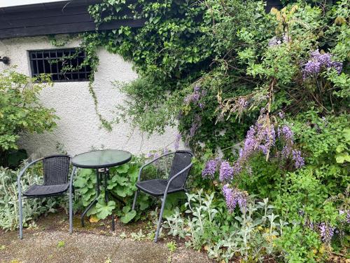 two chairs and a table in a garden at Villa Tullgatan Borgholm in Borgholm