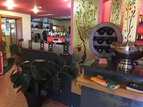 a restaurant with a bar with a counter and a plant at Ostello Trentapassi in Zone