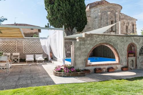 a backyard with a swimming pool and a building at Giardino della Pieve Relais- Adult Only in Cascina