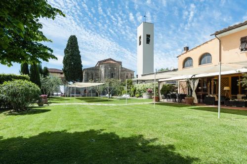 a park with a building and a clock tower at Giardino della Pieve Relais- Adult Only in Cascina
