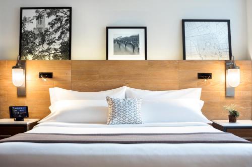 a bedroom with a large bed with three pictures on the wall at AT&T Hotel & Conference Center in Austin