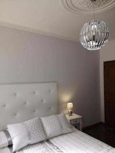 a bedroom with a white bed and two lights at Nature Guesthouse in Lagos