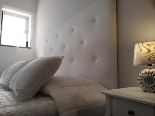a bedroom with a bed with a pillow and a window at Nature Guesthouse in Lagos