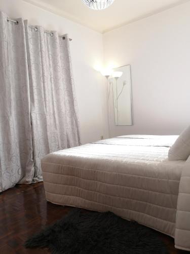 a bedroom with a bed and a lamp and curtains at Nature Guesthouse in Lagos