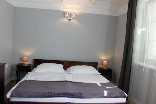 a bedroom with a bed with two night stands and a window at Varga Villa in Orfű