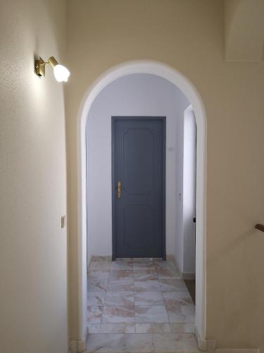 a hallway with a blue door and a tile floor at Nature Guesthouse in Lagos