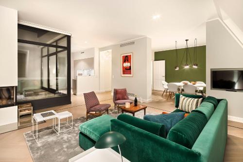 ein Wohnzimmer mit einem grünen Sofa und einem Esszimmer in der Unterkunft Lux 11 Berlin-Mitte in Berlin