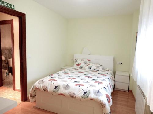 a bedroom with a bed with a comforter on it at Apartamento del Rosario in Corella