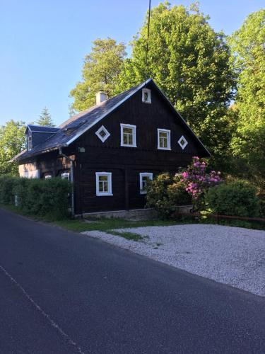 a black house with white windows and a driveway at Chalupa Rozmarýna in Mařenice
