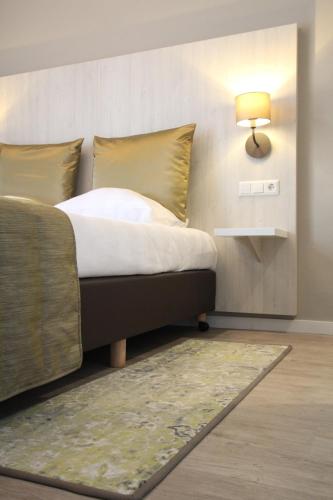 a bedroom with a bed with a lamp and a rug at Apple Inn Hotel in Amsterdam