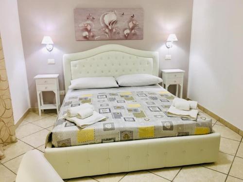 1 dormitorio con 1 cama blanca grande y 2 mesas en b&b I Mori en Noto Marina