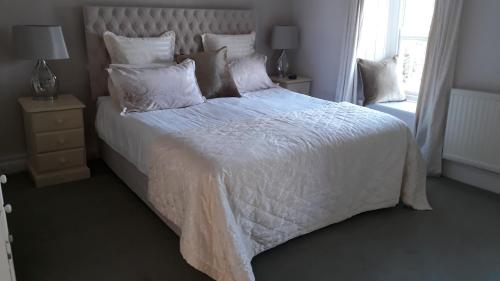 a bedroom with a white bed with white sheets and pillows at The Draen Bed and Breakfast in Brecon