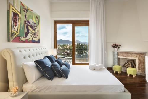 a bedroom with a large white bed with a fireplace at Luxury Rooms & Suites in Olbia