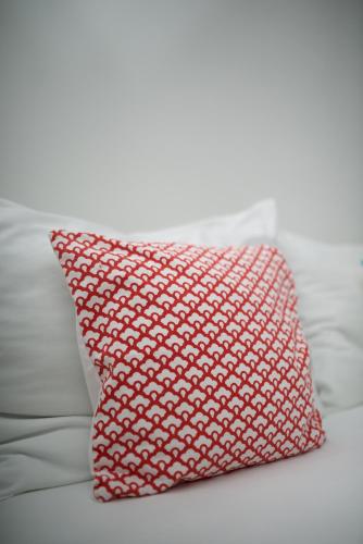 a red pillow sitting on top of a bed at Apartments and Rooms Jospino in Mali Lošinj