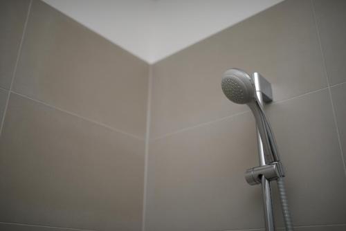a shower with a blow dryer in a bathroom at Apartments and Rooms Jospino in Mali Lošinj