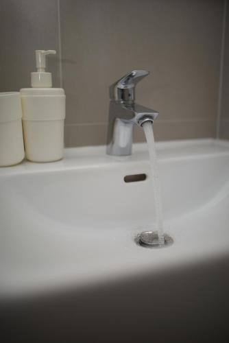 a bathroom sink with water running from a faucet at Apartments and Rooms Jospino in Mali Lošinj