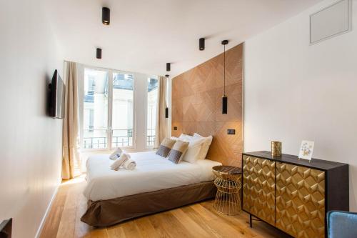 ein Schlafzimmer mit einem Bett und einem großen Fenster in der Unterkunft CMG Champs Elysées - Boetie 6 in Paris