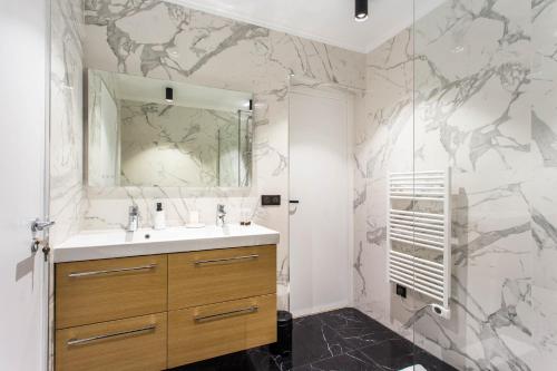 ein Bad mit einem Waschbecken und einem Spiegel in der Unterkunft CMG Champs Elysées - Boetie 6 in Paris