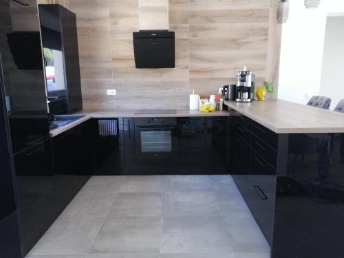 a kitchen with black cabinets and a white counter top at Villa Orao in Kastel Novi