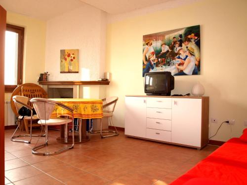 sala de estar con mesa y TV en Nido sul Lago Maggiore en Maccagno Superiore