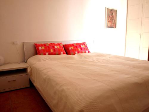 1 dormitorio con 1 cama grande con almohadas rojas en Nido sul Lago Maggiore en Maccagno Superiore