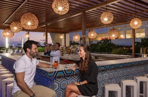 a man and a woman sitting at a table at Grand Sirenis Riviera Maya Resort & Spa All Inclusive in Akumal