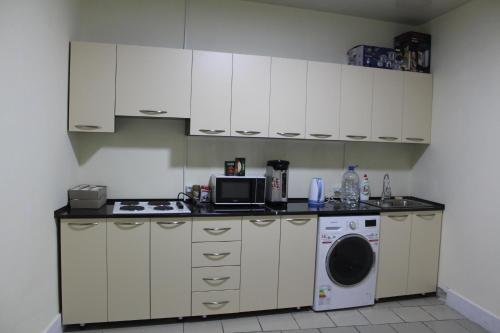 a kitchen with a stove top oven and a microwave at Park Hostel Osh in Osh