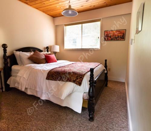 a bedroom with a bed with a wooden ceiling at The Surf Lodge and Pub in Gabriola